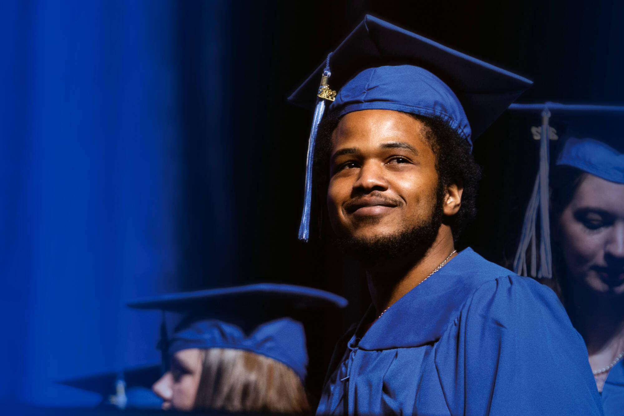 A graduate in a blue cap and gown